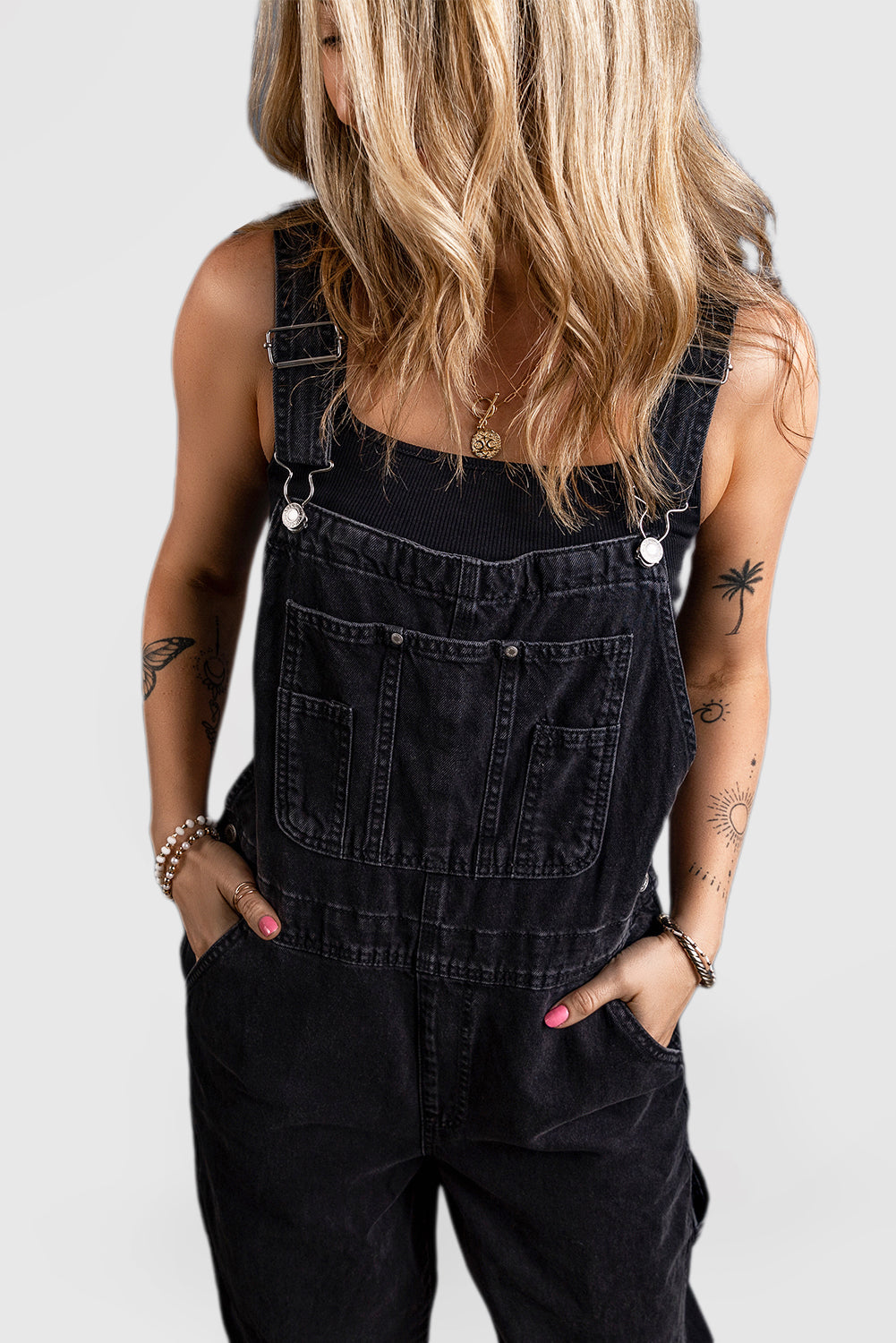 Black denim jumpsuit with adjustable buckle straps and multiple pockets