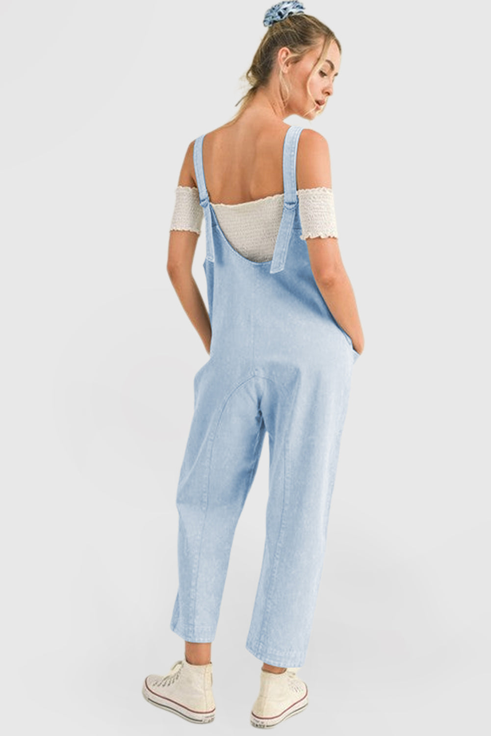 Blue V-neck denim jumpsuit with adjustable straps and pockets