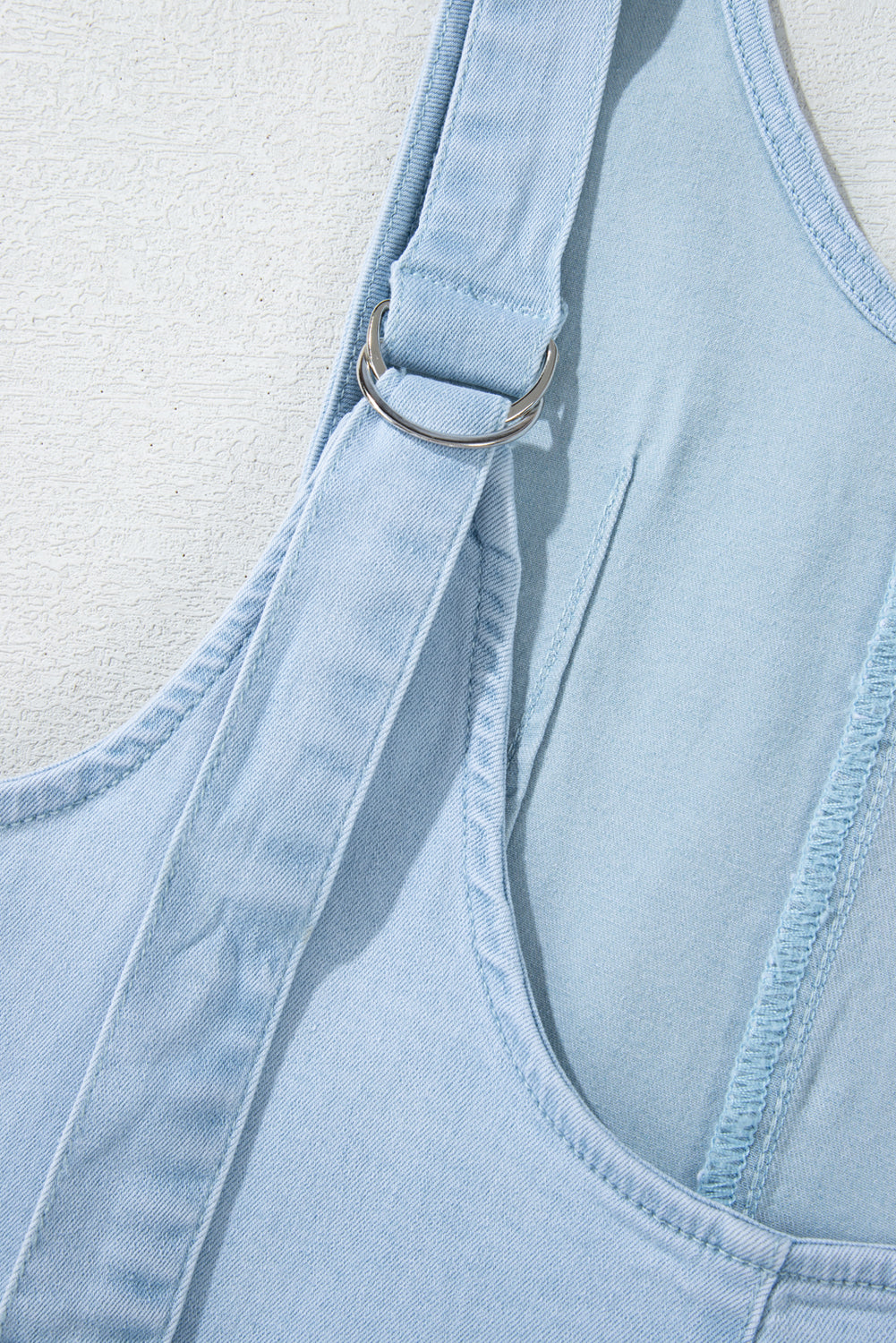 Blue V-neck denim jumpsuit with adjustable straps and pockets