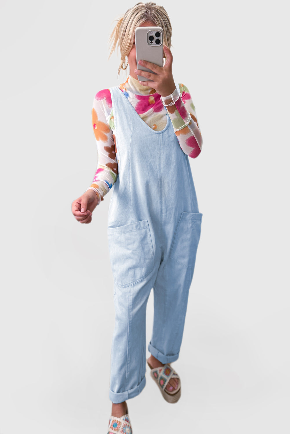 Blue V-neck denim jumpsuit with adjustable straps and pockets