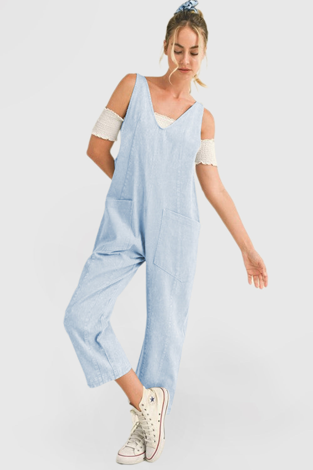 Blue V-neck denim jumpsuit with adjustable straps and pockets