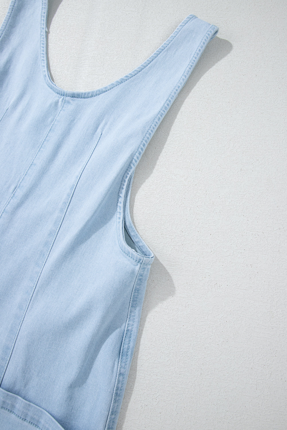 Blue V-neck denim jumpsuit with adjustable straps and pockets