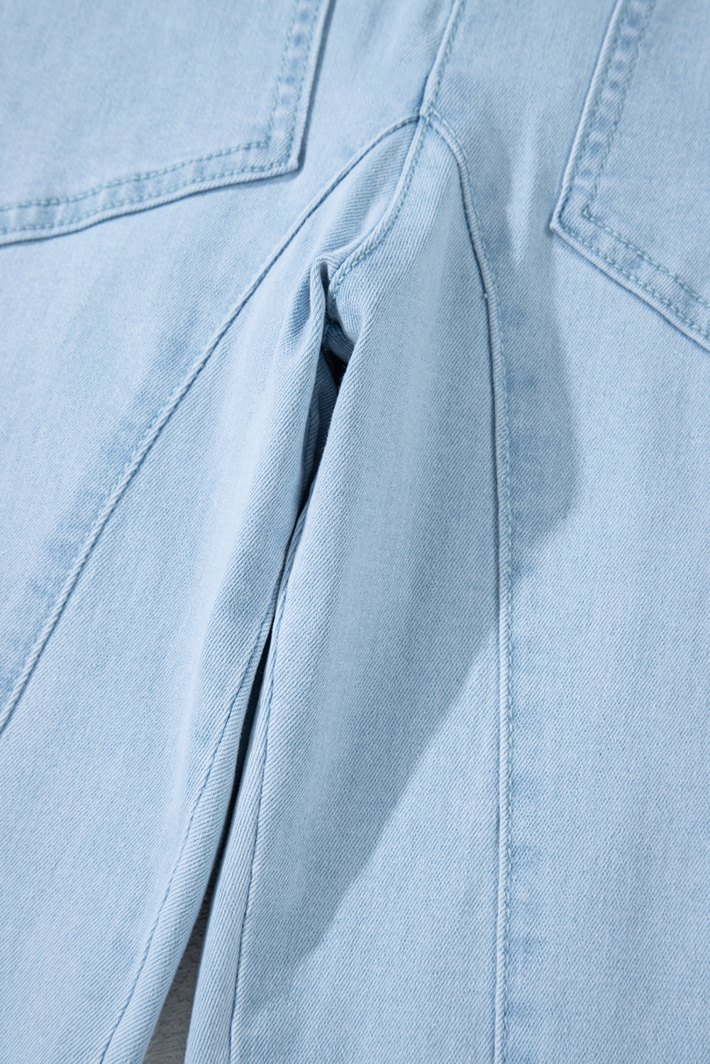 Blue V-neck denim jumpsuit with adjustable straps and pockets